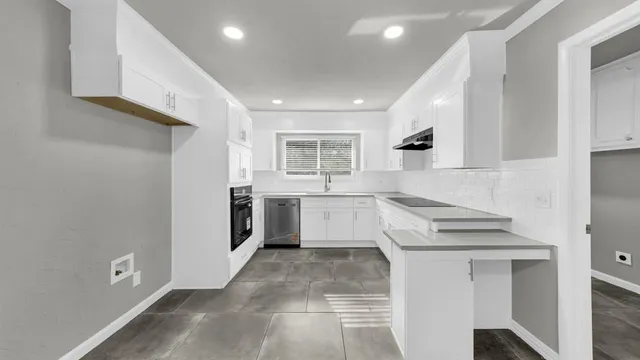 a kitchen with stainless steel appliances a stove a sink and a refrigerator