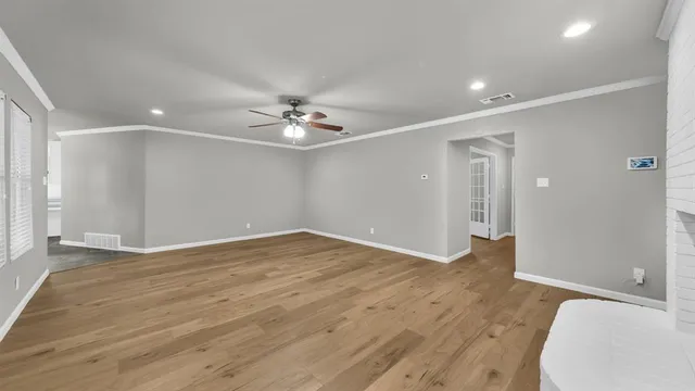 a view of an empty room with wooden floor