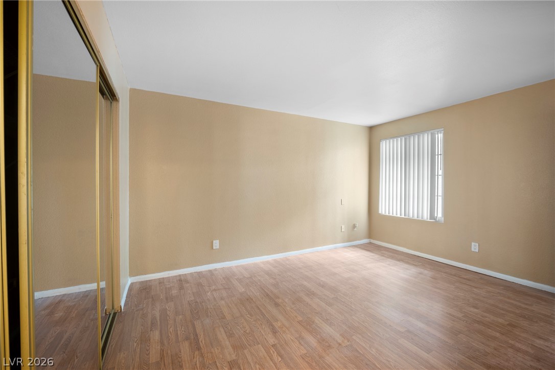 3145 East Flamingo Road, Unit 1055 Las Vegas, NV 89121 - Photo 27 of 40 A generously sized bedroom with ample natural light and a mirrored closet.