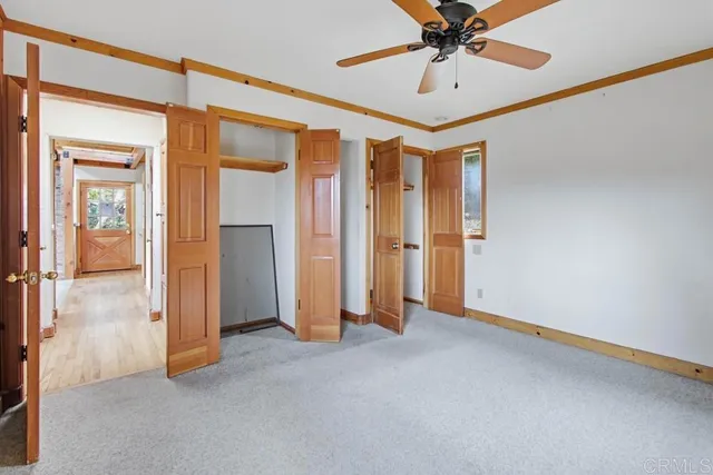 an empty room and chandelier fan