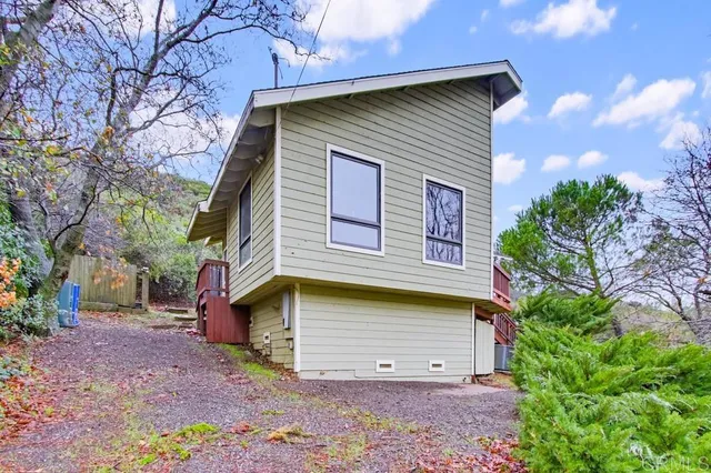 a view of a house with a yard and potted plants