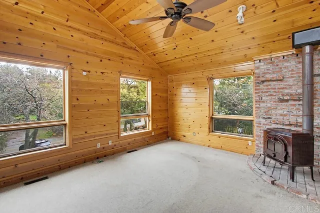 a view of an empty room with a fireplace and a window