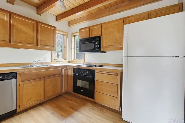 a kitchen with stainless steel appliances granite countertop a refrigerator a stove a sink and a microwave