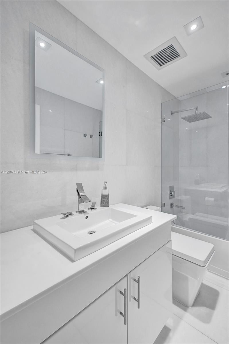 377 Northeast 194th Terrace Miami, FL 33179 - Photo 15 of 19 a bathroom with a sink a toilet and a mirror