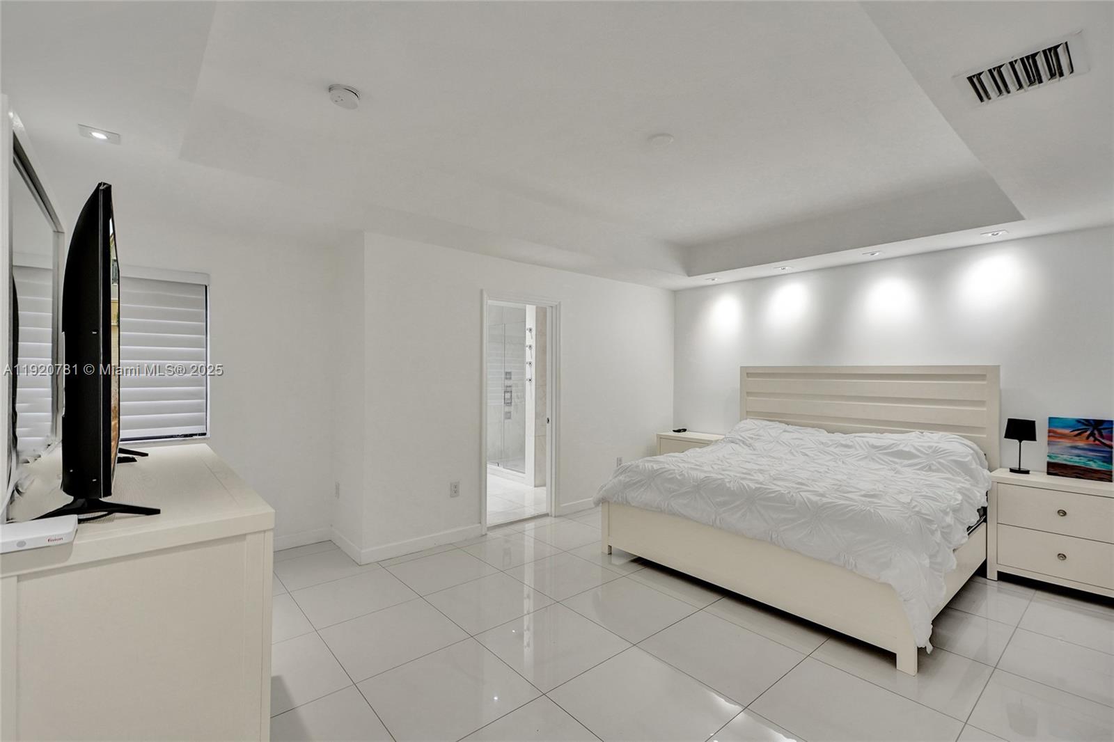 377 Northeast 194th Terrace Miami, FL 33179 - Photo 9 of 19 a bedroom with a bed and a flat screen tv