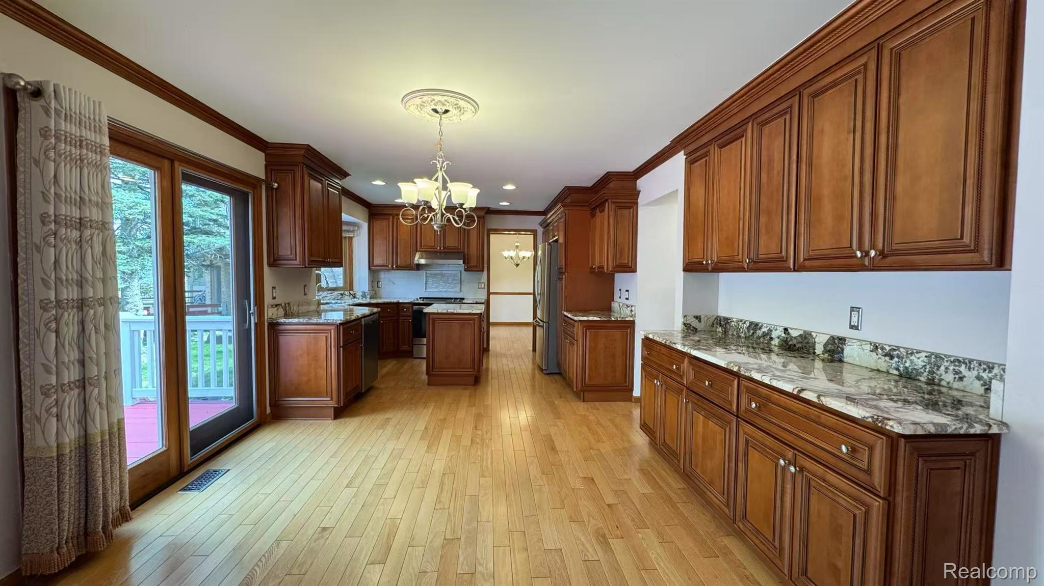 3440 Salem Drive Rochester, MI 48306 - Photo 11 of 33 Expansive kitchen featuring wood-finish flooring, abundant wood cabinetry, granite countertops, and a full suite of stainless steel appliances