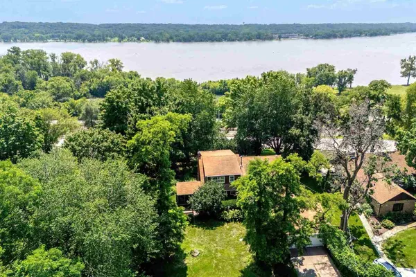 an aerial view of a residential houses with outdoor space and lake view