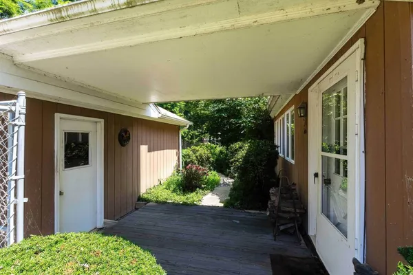 a view of a house with a yard and potted plants