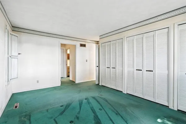 an empty room with a window and a shower curtain