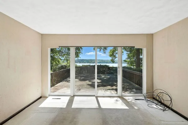 an empty room with windows and balcony
