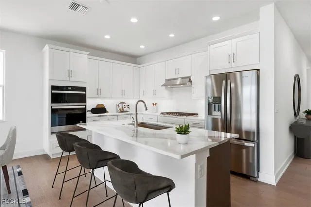 a kitchen with stainless steel appliances a sink and a refrigerator