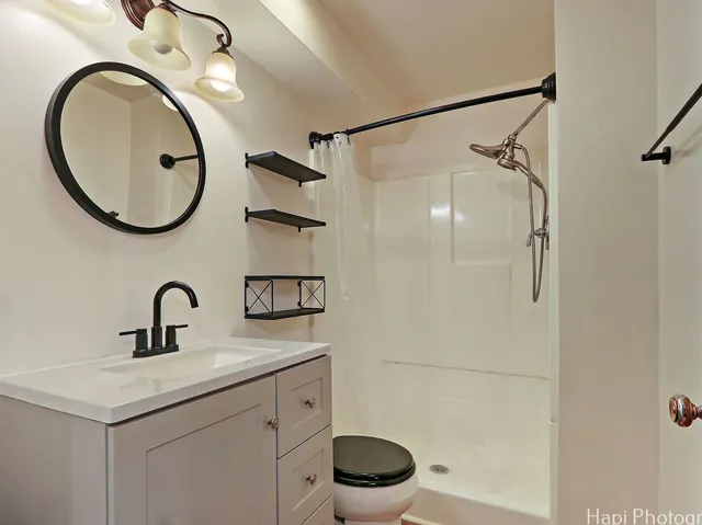 a bathroom with a sink a toilet and a mirror