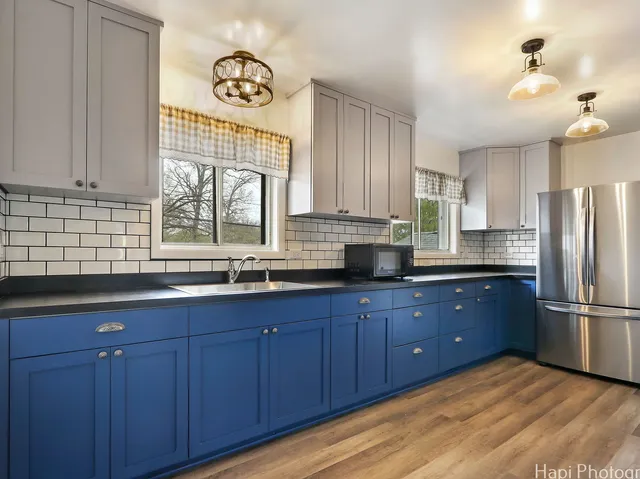 a kitchen with stainless steel appliances granite countertop a sink a window and wooden cabinets