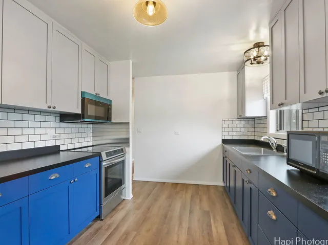 a kitchen with stainless steel appliances granite countertop a sink stove and microwave