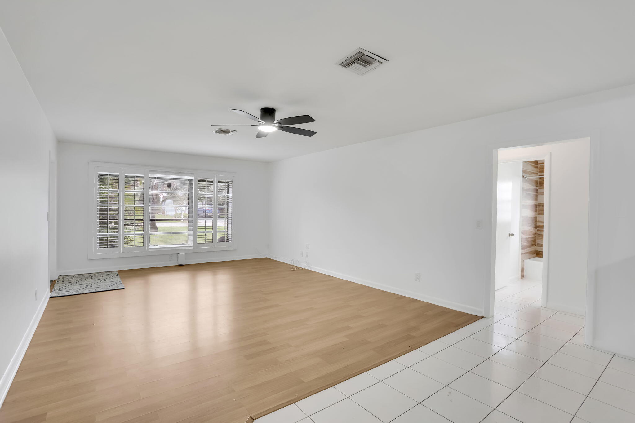 631 Bailey Street Boca Raton, FL 33487 - Photo 4 of 31 a view of an empty room with a window and wooden floor