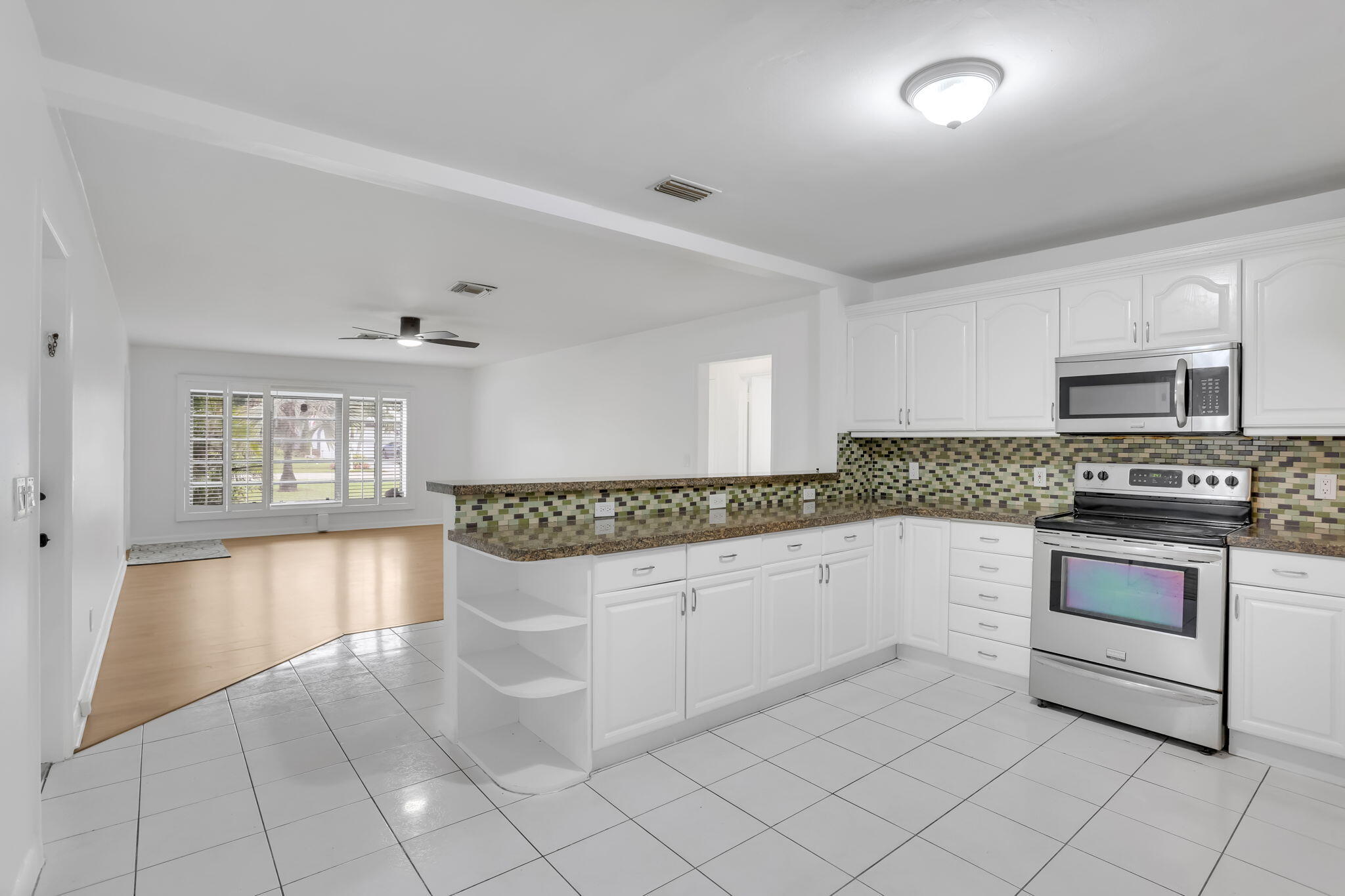 631 Bailey Street Boca Raton, FL 33487 - Photo 10 of 31 a kitchen with granite countertop white cabinets and white appliances