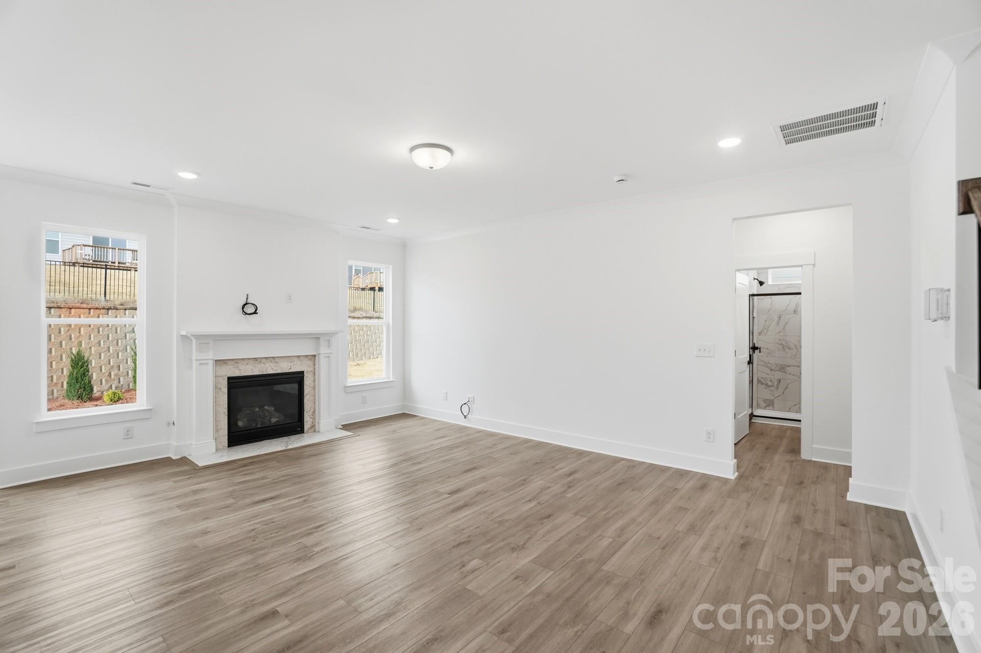 115 Longwood Road Mooresville, NC 28115 - Photo 16 of 43 an empty room with wooden floor fireplace and windows