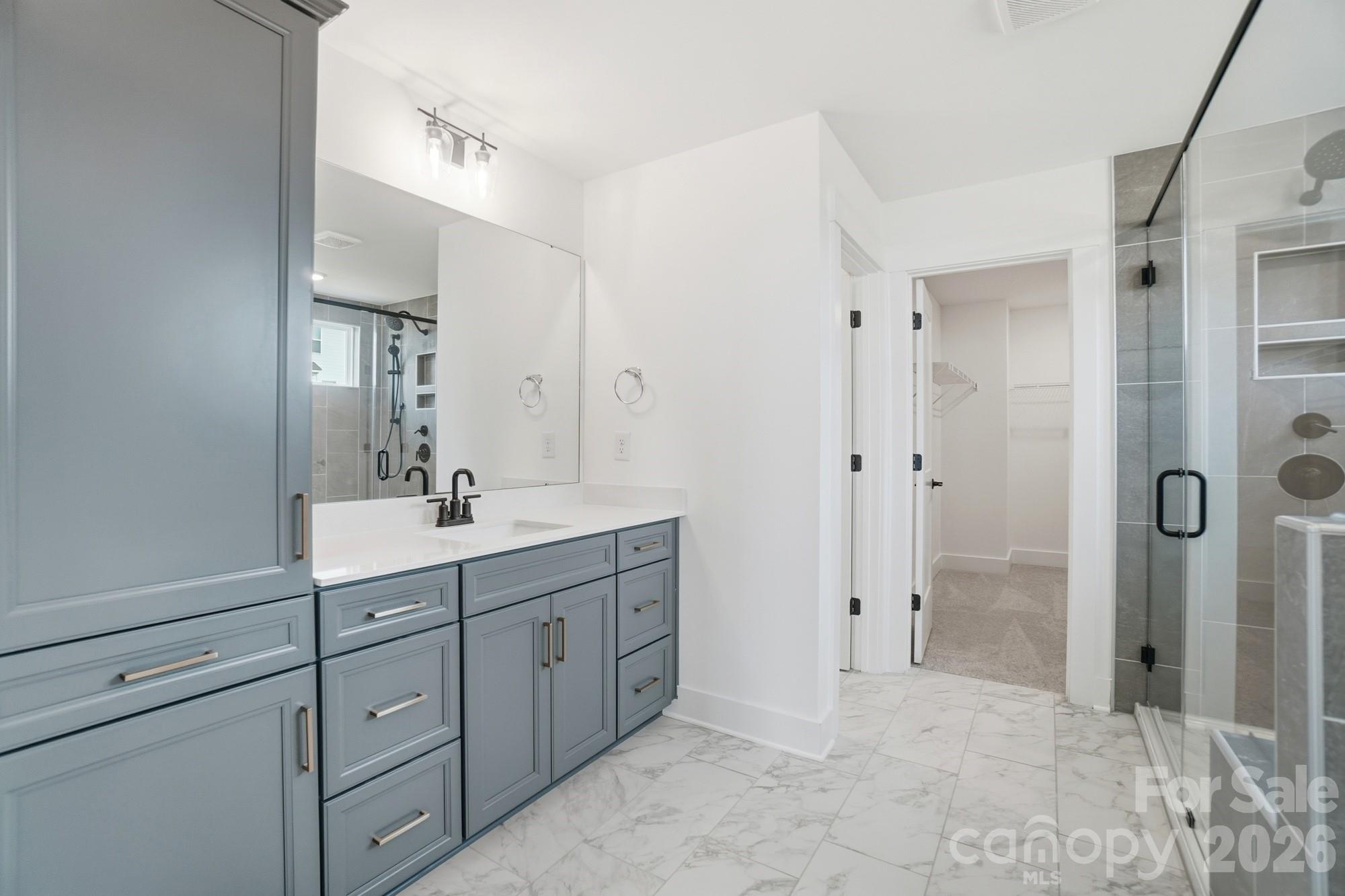 115 Longwood Road Mooresville, NC 28115 - Photo 31 of 43 a spacious bathroom with a shower sink and mirror