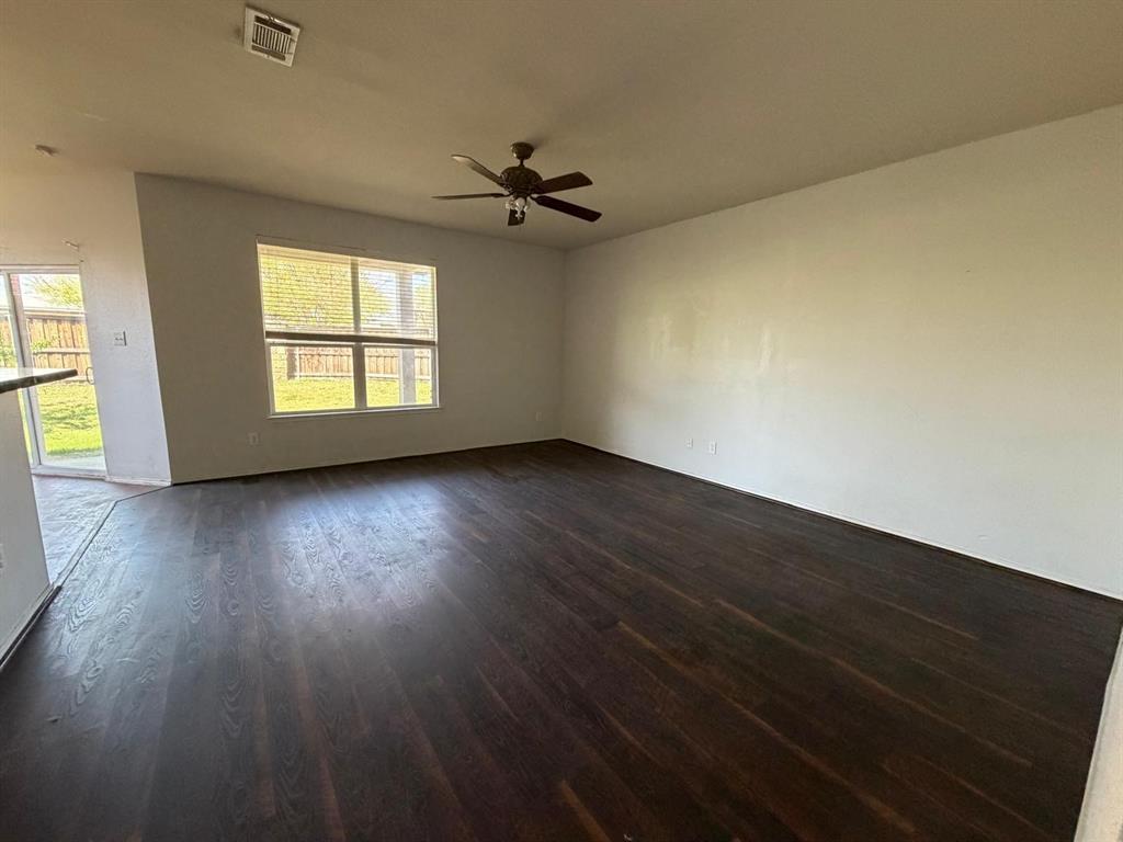 10400 Wagon Rut Court Fort Worth, TX 76108 - Photo 13 of 26 Empty room with ceiling fan and dark wood-style flooring
