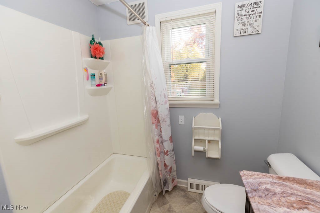 1085 Novak Road Grafton, OH 44044 - Photo 17 of 41 Bathroom featuring vanity, shower / bath combination with curtain, and light tile patterned floors