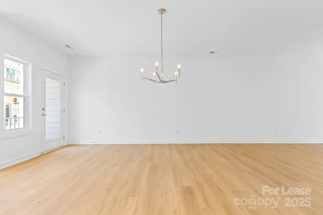 a view of a room with wooden floor and white walls