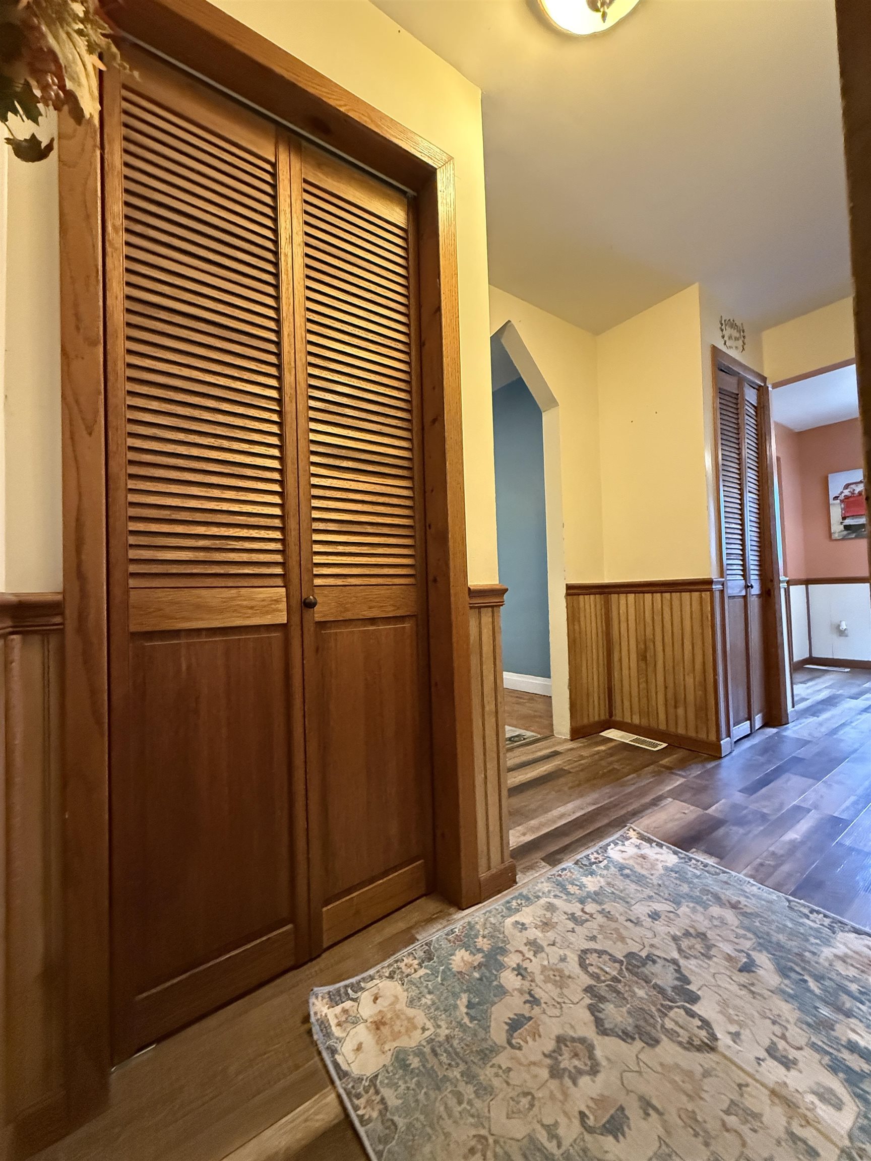 809 16th Street North Virginia, MN 55792 - Photo 25 of 44 Hallway with wood finished floors, a wainscoted wall, arched walkways, and wood walls