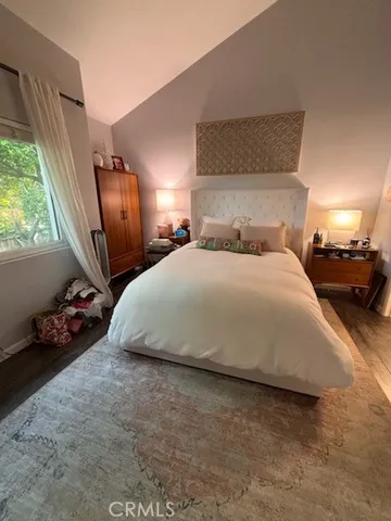 a large bed sitting in a bedroom next to a window