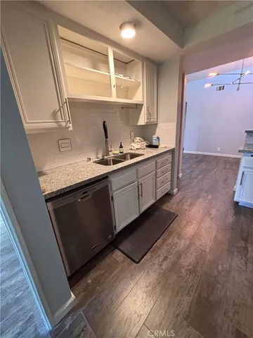 a kitchen with granite countertop a sink and cabinets