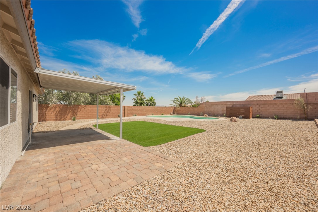 112 Iridescent Street Henderson, NV 89012 - Photo 17 of 24 A private desert oasis with a covered patio, artificial turf, and a refreshing pool.