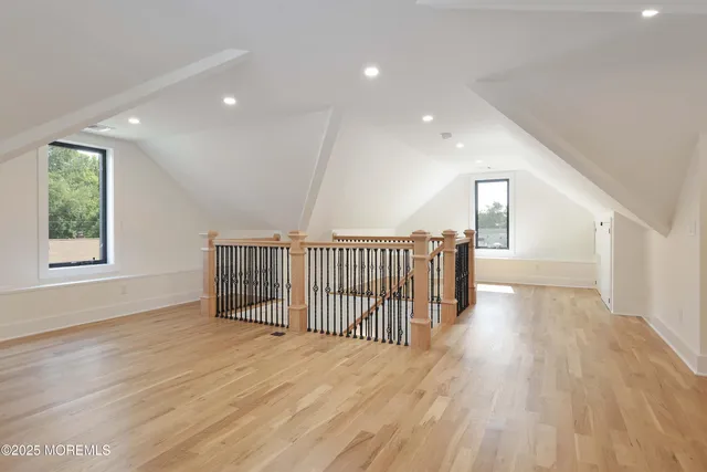 a view of a hallway with wooden floor and windows
