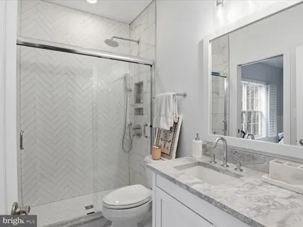 a bathroom with a granite countertop sink toilet and shower
