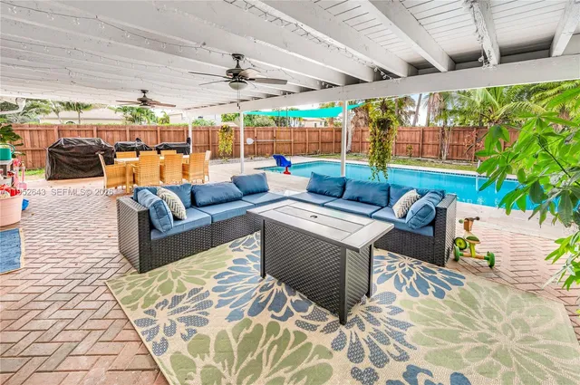 a living room with stainless steel appliances furniture a fireplace and a open kitchen view