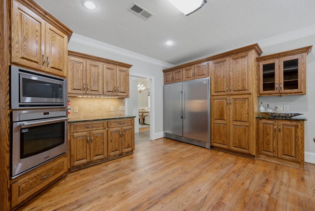 582 Knox Chapel Road Social Circle, GA 30025 - Photo 9 of 49 a kitchen with granite countertop wooden floors stainless steel appliances and a window
