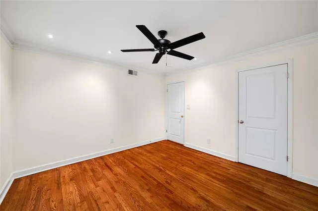 a view of empty room with wooden floor