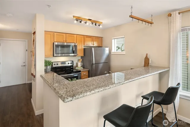 a kitchen with stainless steel appliances granite countertop a sink dishwasher and a refrigerator