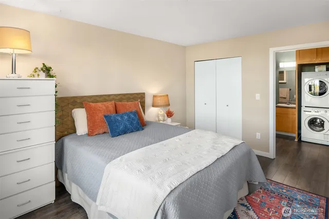 a bedroom with a bed and a lamp on dresser