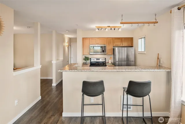 a kitchen with stainless steel appliances kitchen island a table and chairs in it
