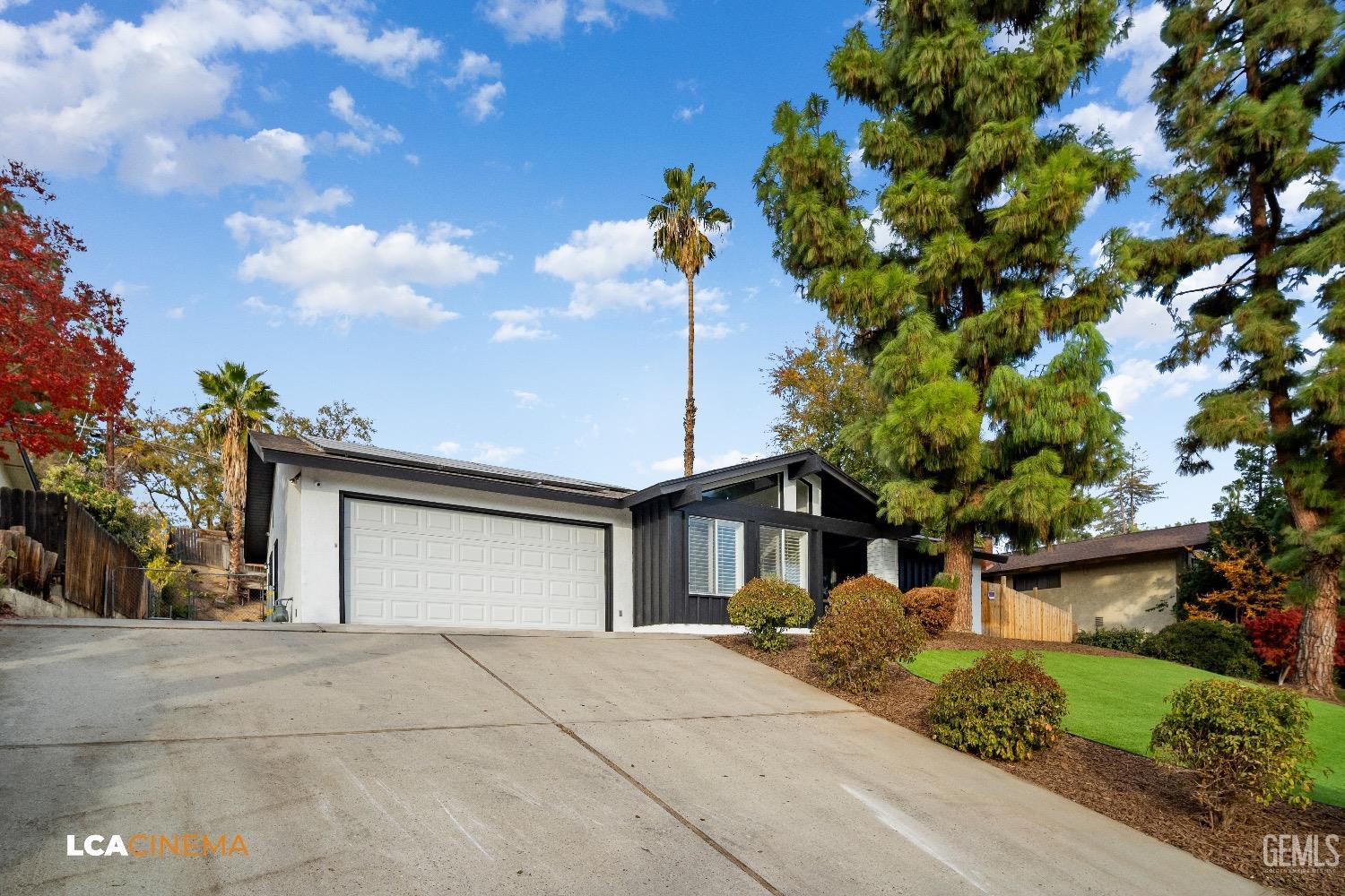 Undisclosed Address Bakersfield, CA 93306 - Photo 3 of 24 a front view of a house with a yard and garage