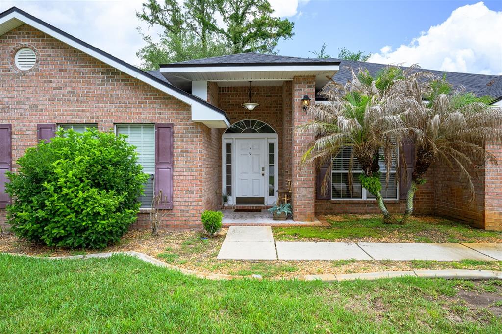 11 Riddle Drive Palm Coast, FL 32164 - Photo 3 of 33 a front view of a house with a yard and plants