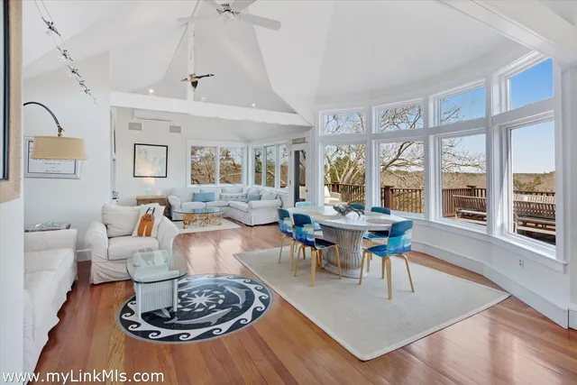 a view of a dining room with furniture a chandelier and wooden floor