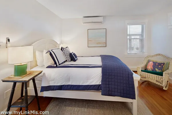 a bedroom with a bed and a lamp on dresser