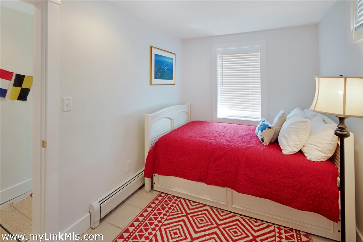 72 Chappaquiddick Avenue Edgartown, MA 02539 - Photo 29 of 63 a bedroom with a bed and a lamp on dresser