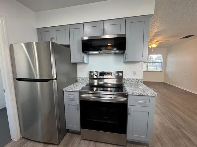 a kitchen with stainless steel appliances granite countertop a stove a refrigerator and a microwave