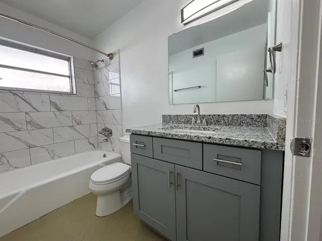 a bathroom with a bathtub toilet and window