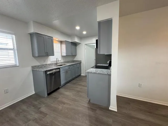 a kitchen with granite countertop a stove and a refrigerator