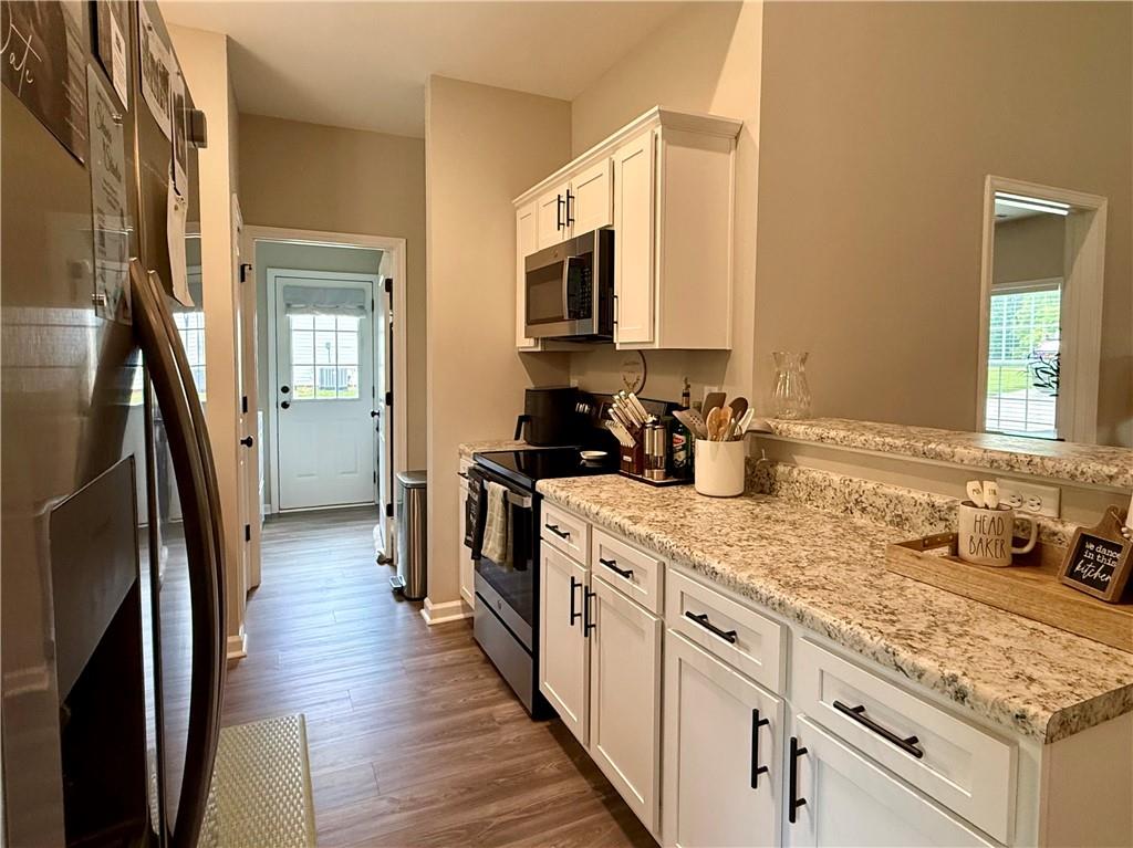 1776 Pleasant Grove Road Temple, GA 30179 - Photo 11 of 45 a kitchen with stainless steel appliances granite countertop a refrigerator a stove and a sink with wooden floor