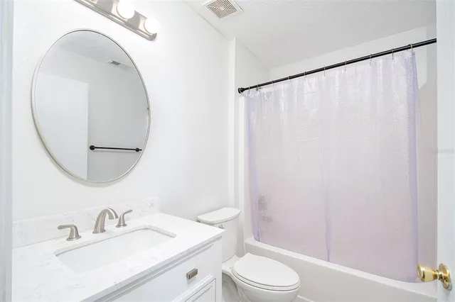 a bedroom with a bed lamp and a potted plant