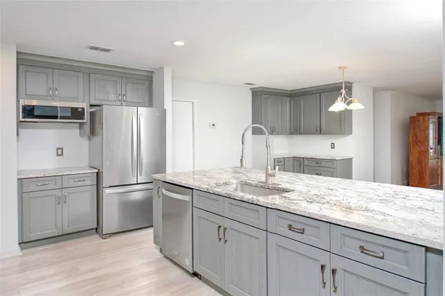 a kitchen with a refrigerator sink and cabinets