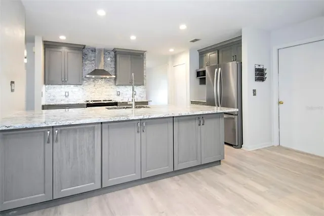 a view of a kitchen with stainless steel appliances granite countertop a refrigerator and a sink