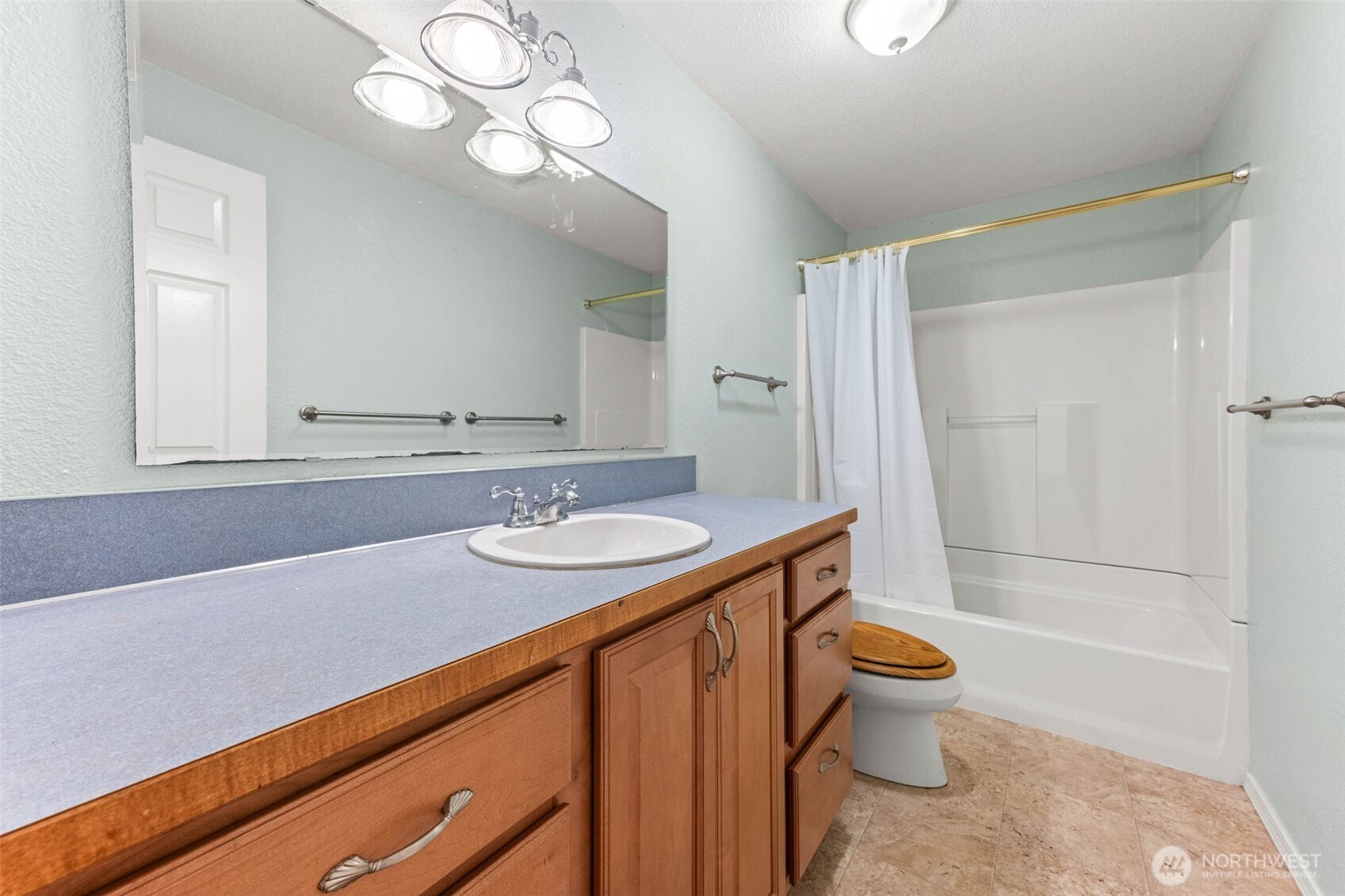 8529 37th Court Southeast Lacey, WA 98503 - Photo 17 of 34 a bathroom with a sink a toilet a mirror and shower